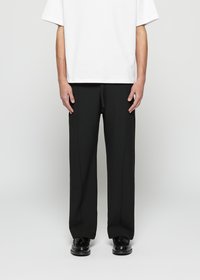 Calças pretas ajustadas com perna reta, apresentando um cinto de cordão e bolsos laterais, combinadas com uma t-shirt oversized branca.