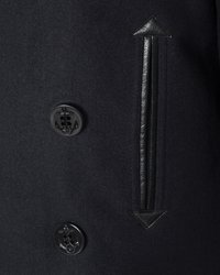 Czarny wełniany płaszcz z dużymi czarnymi guzikami w kształcie kotwicy, skórzanymi akcentami i pionowym wzorem w paski. Strzałkowy kształt na górze.