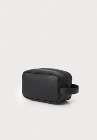 Trousse de toilette rectangulaire noire en matériau synthétique lisse. Elle dispose d'une fermeture zippée et d'une poignée latérale pour un transport facile.