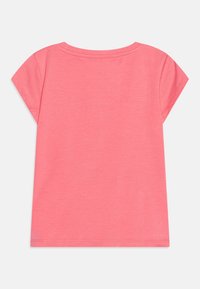 Bluzka z krótkim rękawem w jasnoróżowym kolorze, wykonana z miękkiej bawełny, z okrągłym dekoltem i luźnym krojem, z prostym dołem i czystymi szwami.