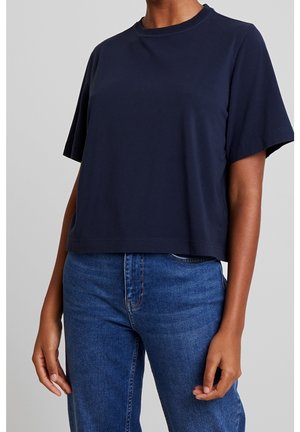 Marineblaues Baumwoll-T-Shirt mit kurzen Ärmeln, Rundhalsausschnitt und kurzem Saum. Glatte Struktur mit dezenten Nahtdetails.