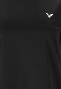 Sort atletisk T-shirt lavet af glat stof med rund hals, prydet med et lille hvidt logo øverst til venstre.