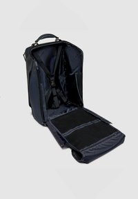 Marineblauwe rugzak, rechthoekige vorm, gemaakt van duurzaam materiaal. Voorzien van verstelbare bandjes, ritsen en een ruim, open interieur met gaaspockets.