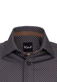 Camicia a fantasia nera e marrone con un design geometrico, dotata di colletto classico e una fodera interna marrone al collo.