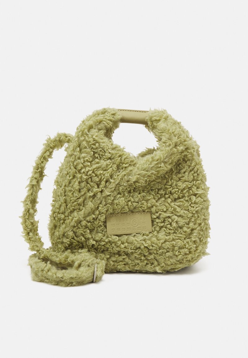 Sac à main en fausse fourrure bouclée vert clair avec poignée supérieure, bandoulière amovible et patch logo rectangulaire à l'avant.