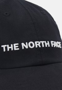 Sort baseball cap med broderet tekst "THE NORTH FACE" i hvid foran. Har en afrundet skygge og tekstiler med struktur.