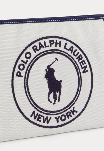 Κεντημένο λογότυπο Polo Ralph Lauren με παίκτη πόλο πάνω σε άλογο και το κείμενο «Polo Ralph Lauren New York» σε λευκό υφασμάτινο φόντο.