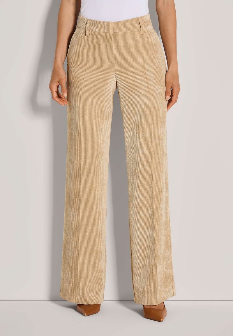Beige corduroy wijde broek met verticale ribbels, met een platte voorkant, ceintuurlussen en een gladde textuur. Aangevuld met bruin puntige hakschoenen.