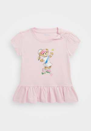 Robe de bébé rose pâle avec ourlet à volants, ornée sur le devant d'un ours jouant au tennis portant une jupe, une visière et des baskets.