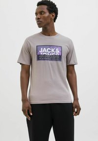 Grijze katoenen t-shirt met een paarse grafische print en de tekst "JACK & JONES", ronde halslijn, korte mouwen en een ontspannen pasvorm.