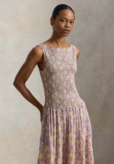 Μωβ φόρεμα χωρίς μανίκια με κίτρινο φλοράλ μοτίβο, ελαστικό μπούστο με ρίγες, ροή φούστας και μαλακή υφή υφάσματος.