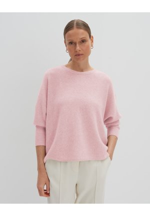 Rosa Strickpullover mit lockerer Passform, gerippten Bündchen und rundem Ausschnitt. Weiche Textur, kombiniert mit cremefarbenen Hosen.
