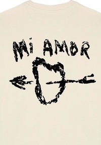Felpa di colore panna con una grafica nera prominente che presenta il testo "Mi Amor" sopra una forma a cuore attraversata da una freccia.