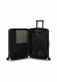 Maleta rígida azul marino con compartimentos abiertos, correas cruzadas en un lado, bolsillo de malla con cremallera en el otro y un asa retráctil.