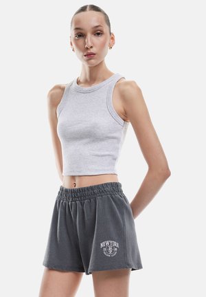 Harmaa ribattua lyhythihaista toppia, joka on yhdistetty löysiin tummanharmaisiin shortseihin, joissa on elastinen vyötärö ja valkoinen "NEWYORK"-logo.