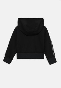 Hoodie preto cropped com capuz, punhos e cintura canelados. Apresenta texto branco ao longo das mangas. Feito de tecido macio.
