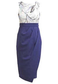 Robe sans manches avec haut blanc présentant des motifs de feuilles noires et violettes et jupe crayon bleu foncé taille haute avec un pli à l'avant.