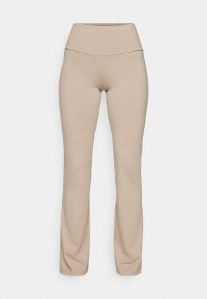 Beige leggings with a high waistband, made from soft, stretchy fabric. Features a smooth texture and fitted design tapering at the ankle.