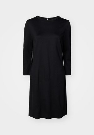 Robe noire à mi-cuisse avec un col rond, des manches longues et une fermeture éclair au dos. Tissu lisse de couleur unie sans motifs.