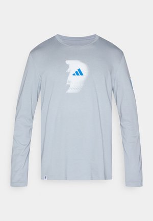 Cămașă gri deschis cu mâneci lungi, realizată din țesătură moale, cu un design grafic alb și albastru pe față și un accent albastru pe mânecă.