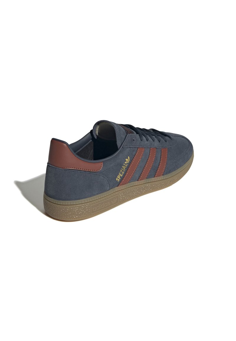 Męskie szare zamszowe sneakersy z brązowymi skórzanymi akcentami, z trzema paskami po bokach i teksturowaną gumową podeszwą. Złoty detal z logo.