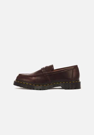 Tumedatpruun nahast loafer musta pakse tallaga, kollaste õmblustega ja peal oleva penny-rihma detailiga.