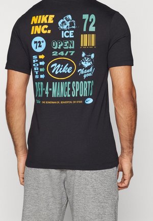 Sort Nike T-shirt med farverig tekst og grafik, herunder "Nike Inc.", isterninger, et katteansigt, "72", stregkode og "Pep-4-Mance Sports" på bagsiden.
