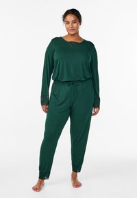 Zelen komplet udobnih oblačil z dolgimi rokavi, ki ima izrez okrašen z čipko in čipkaste robove na rokavih in hlačah; mehka, udobna tkanina.