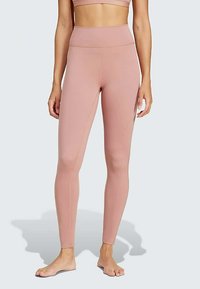 Rozā augsta vidukļa legingi, izgatavoti no elastīga auduma, ar gludu tekstūru un pieguļošu dizainu, apvienoti ar atbilstošu īsu augšu.