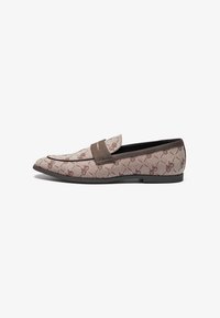 Loafer aus strukturiertem beigem Stoff mit einem braunen Akzentriemen. Mit einem dezenten Muster und einer flachen schwarzen Sohle.