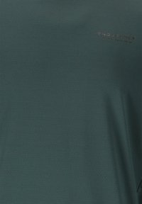 T-shirt med kort ärm i djup teal, med subtila präglade mönster och "ENDURANCE"-logotyp i mörkgrått på bröstet.