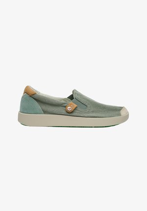 Zapato casual tipo slip-on en tejido verde claro con suela beige y detalles en cuero marrón claro en el talón y botón lateral.
