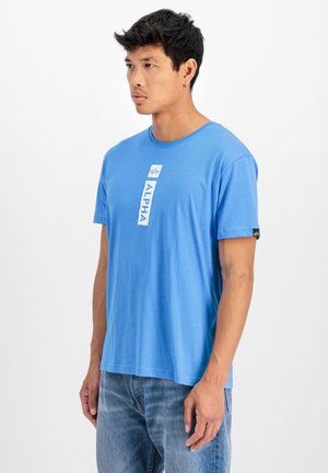 Helles blaues Baumwoll-T-Shirt mit einem weißen "ALPHA"-Grafik auf der Vorderseite und einem kleinen Logo am Ärmel. Kurze Ärmel, Rundhalsausschnitt-Design.