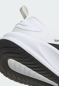Zapatilla deportiva blanca, con un upper texturizado, acentos lisos, suela de goma negra con diseño de banda de rodadura ondulada y lengüeta trasera para facilitar su colocación.
