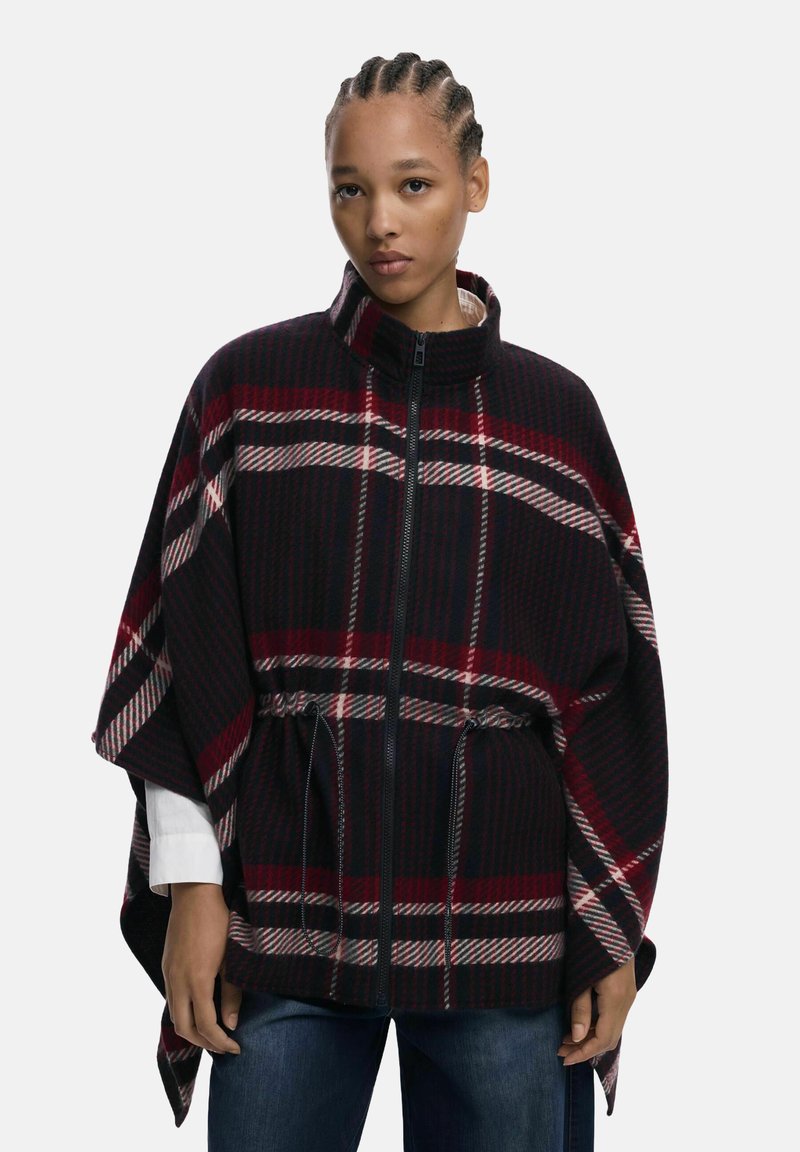 Kariertes Poncho aus Wollmischung mit hochgeschlossenem Kragen, Reißverschluss und elastischem Bund. Farben sind Schwarz, Rot und Creme mit strukturierter Oberfläche.