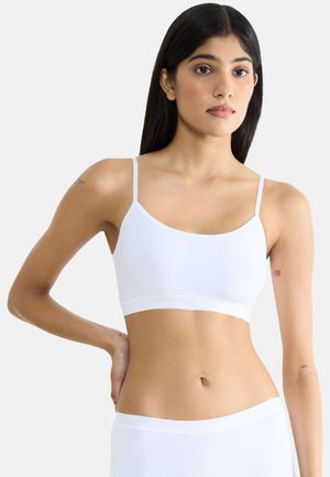 Bralette bianco senza cuciture con spalline sottili, un elastico largo e una texture liscia. Presenta un design minimalista, adatto per essere indossato a strati e per il comfort.