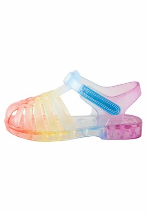 Sandalia de plástico translúcido con tiras de degradado arcoíris, diseño de tira en T y cierre ajustable de Velcro azul en el tobillo.