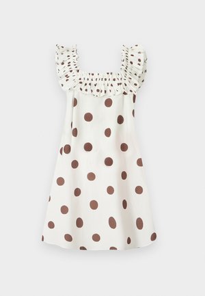 Robe blanche sans manches à pois marron, avec un décolleté carré et des bretelles à volants.
