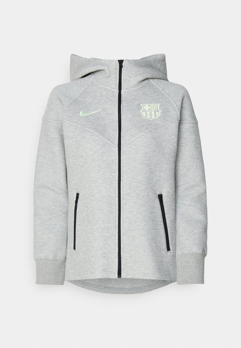 Jasnoszara bluza z kapturem na zamek błyskawiczny, czarne kieszenie na zamek, oraz zielone logo Nike. Na piersi znajduje się herb Barcelony.