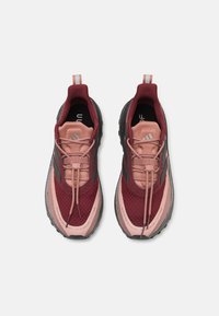Scarpe sportive con tomaia in rete bordeaux, accenti rosa e suola in gomma grigia; progettate con lacci e punta rinforzata per maggiore durabilità.