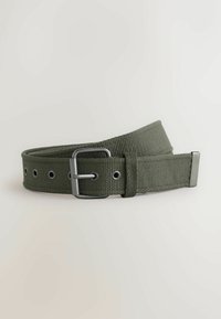 Olive green woven fabric belt with metal buckle and eyelets, coiled against a plain light background.