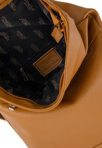 Brun lædertaske med åben toplynlås, der viser sort indvendig foret med "Venezia Made in Italy" og en intern lynlåslomme.