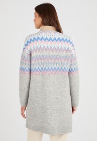 Cappotto di maglione grigio con un motivo geometrico in rosa, blu e bianco sull'inserto, dotato di colletto alto e maniche lunghe.