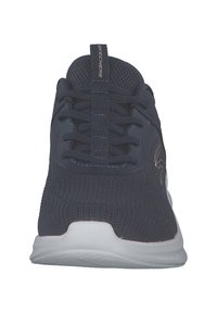 Scarpe da ginnastica navy con tomaia in maglia traspirante, lacci piatti e suola bianca. Presentano un'etichetta sul tallone con il logo "Skechers".