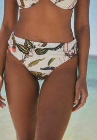 Aukštu liemeniu bikini apatiniai su gėlių raštu, vaizduojančiais palmių lapus ant balto fono, susiraukšlėta liemenėlė, vidutinė aprėptis ir minkšta medžiaga.