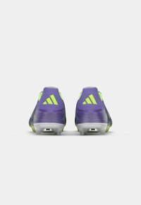 Purple and neon green soccer cleats with a textured design, featuring a low-profile silhouette and studded outsole for grip.