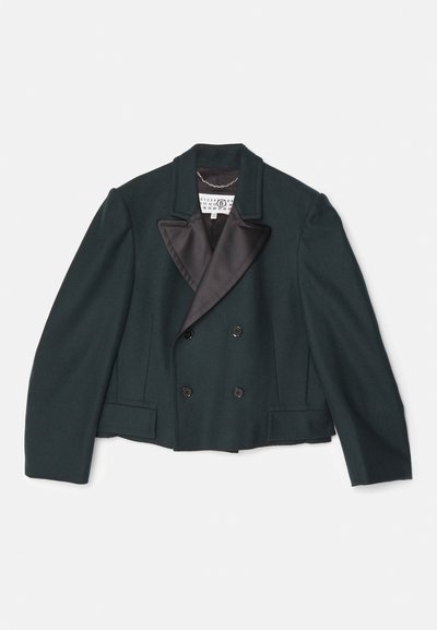 Kratki dvostruko kopčani kaput u tamnozelenoj vuni, s crnim satenom i šiljastim reverima, koji ima dva prednja džepa i crne dugmadi.