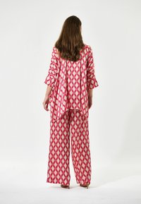 Röd och vit geometrisk mönstrad oversized topp och byxset med vida ben, med en lös passform och 3/4-bellärmar, tillverkad av lättviktigt material.