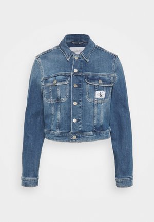 Kort denim jasje in middelblauw met twee frontzakken, zilveren knopen en een CK-logo patch. Heeft lange mouwen en stiksels.