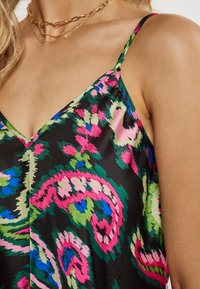 Camisole negru vibrant, cu un model paisley în roz, verde și albastru. Material neted, bretele ajustabile și design cu decolteu în V.